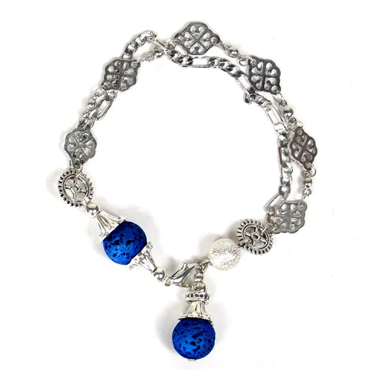 Silver-tone bracelet with ornate links, gear-like discs, blue beads and a clear bead